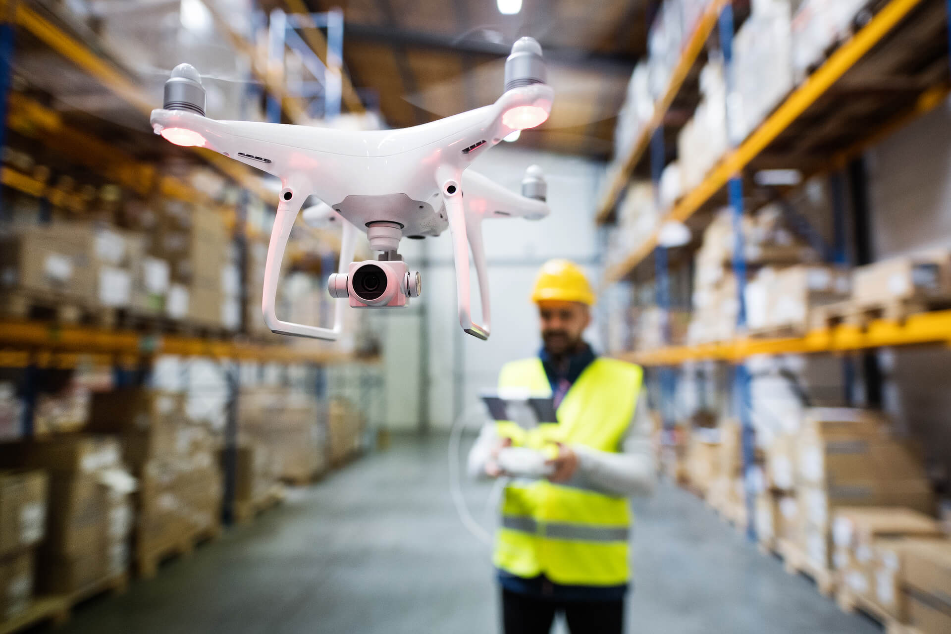 Flying A drone in a warehouse by a man